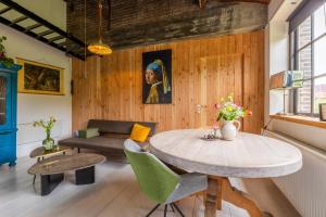 a living room with a table and a couch at Appartement de Tuinkamer in Kampen