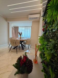 a living room with a table and chairs and plants at Luma Apartment in Tecuci +20 photos