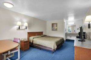 a small hotel room with a bed and a desk at Knights Inn Jacksonville at Dix Ellis Trail in Sunbeam