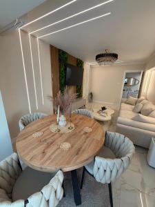 a living room with a wooden table and chairs at Luma Apartment in Tecuci