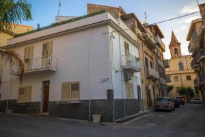 a white building on the side of a street at White Duomo Rooms in SantʼAgata di Militello