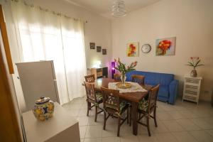 a dining room with a table and a blue couch at White Duomo Rooms in SantʼAgata di Militello