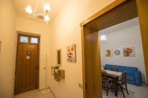 a dining room with a table and a blue couch at White Duomo Rooms in SantʼAgata di Militello