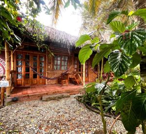 a wooden house with a hammock in front of it at Hostal Rosa Mística in Montañita