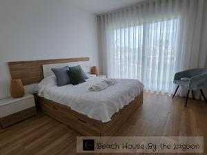 a bedroom with a bed with two towels on it at Beach House by the Lagoon - Piscina Privada in Casal do Narcizo +51 photos