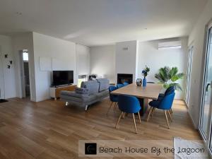 a living room with a wooden table and blue chairs at Beach House by the Lagoon - Piscina Privada in Casal do Narcizo