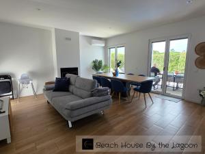 a living room with a couch and a table at Beach House by the Lagoon - Piscina Privada in Casal do Narcizo
