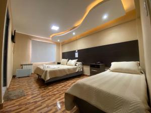 a hotel room with two beds and a projector at Hotel Altos de la Puna in San Antonio de los Cobres