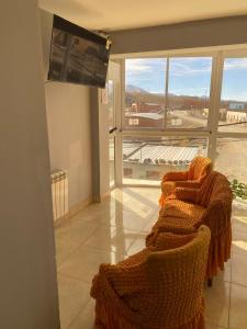 a living room with two chairs and a large window at Hotel Altos de la Puna in San Antonio de los Cobres