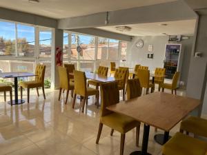 a restaurant with tables and chairs and a clock on the wall at Hotel Altos de la Puna in San Antonio de los Cobres