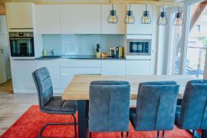 a kitchen with a wooden table and blue chairs at Penthaus Aldebaran by Salzkammergood Living in Tauplitz