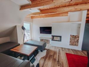 a living room with a couch and a table at Penthaus Aldebaran by Salzkammergood Living in Tauplitz