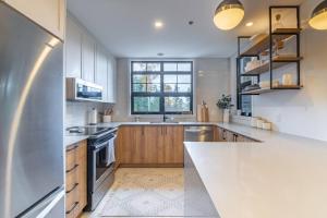 a kitchen with wooden cabinets and a large window at Tremblant Prestige - Les Eaux 215-6 in Mont-Tremblant