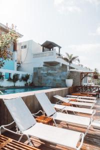 a row of chaise lounge chairs next to a swimming pool at Bartolome Oceanfront Suites in Isla Mujeres