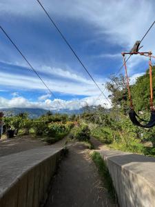 a road next to a retaining wall with a swing at Riverside Estate with Jacuzzi 9 Bedroom 7 Bath in Baños