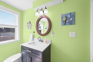 a green bathroom with a sink and a mirror at Luxury Waterfront & Oceanfront Beach Paradise in North Topsail Beach +39 photos