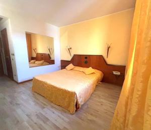 a hotel room with a bed and a mirror at Hotel Cangrande Di Soave in Soave