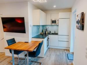 a kitchen with a wooden table and chairs in a room at Apartment Gemini by Salzkammergood Living in Tauplitz