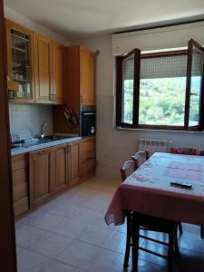 a kitchen with a table and a kitchen with a window at Casa al Pozzarello in Porto Santo Stefano