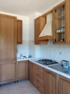 a kitchen with wooden cabinets and a stove top oven at Casa al Pozzarello in Porto Santo Stefano