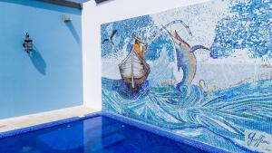 a mural on the wall of a room with a pool at Casa Barco Hotel Boutique in Isla Mujeres