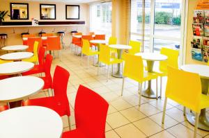 une salle à manger avec des tables et des chaises colorées dans l'établissement Première Classe Annemasse Ville La Grand, à Ville-la-Grand
