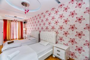 a bedroom with a white bed and a floral wall at Kolorit Modern Apartment in Baku +291 photos