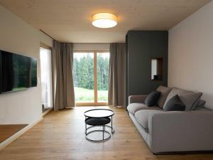 a living room with a couch and a table at Fuxbau Allgäu in Argenbühl