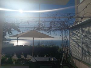 an umbrella sitting on a patio with the view of the ocean at La Diva Adriatica in Podstrana +2 photos