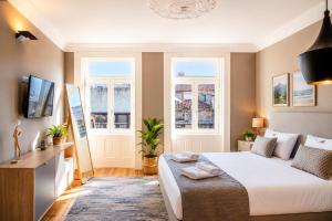 a bedroom with a large bed and two windows at MyStay Porto - Urban Collection in Porto +47 photos
