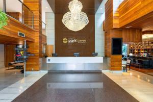 a hotel lobby with a bar and a chandelier at Hotel Park Tower Savassi by Nacional Inn in Belo Horizonte