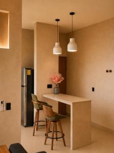 a kitchen with a island with chairs and two pendant lights at Olivo Mio in La Paz