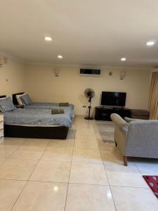 a living room with two beds and a flat screen tv at Studio flat Gants Hill with Free Parking in Redbridge
