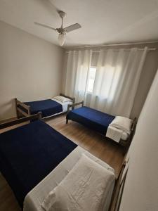 a bedroom with two beds and a ceiling fan at Hotel Deck Taquaral in Campinas