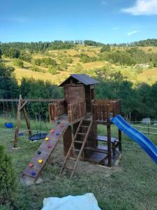 an outdoor playground with a slide and a slideintend at Cabana Colț de liniste in Feldru