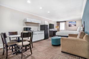 a hotel room with a king bed and a kitchen at Best Western Niceville-Destin in Niceville