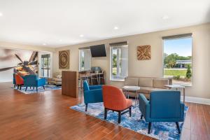 a living room with blue chairs and a couch at Best Western Niceville-Destin in Niceville
