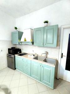 a kitchen with mint green cabinets and a sink at Timo e Lavanda in Albenga +7 photos