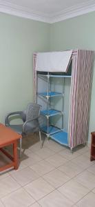 a room with a bed and a chair and a table at DELIGACY RESORT Eldoret in Eldoret