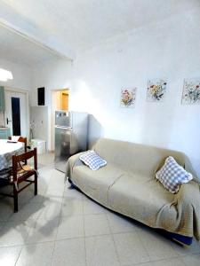 a living room with a couch and a kitchen at Timo e Lavanda in Albenga
