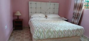 a bedroom with a large bed with a white headboard at DELIGACY RESORT Eldoret in Eldoret +5 photos