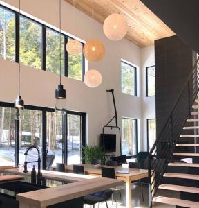a living room with a staircase and some pendant lights at Pur Nature et Spa Owl's Head in Mansonville