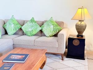 a living room with a couch with green pillows at Best Ocean and Mountain View! in Waikoloa Village +26 photos