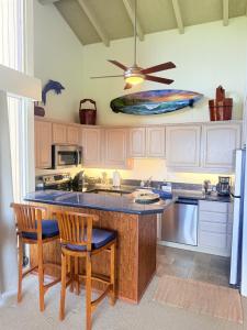 a kitchen with a center island with a surfboard on the wall at Best Ocean and Mountain View! in Waikoloa Village