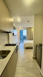 a kitchen with a sink and a room with a bed at Apartaestudio tipo loft cerca al mar in Santa Marta +7 photos