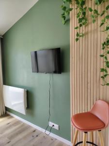 a room with a chair and a television on a wall at Studio indépendant avec parking à Avignon in Avignon
