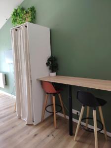 a room with a table and a white refrigerator at Studio indépendant avec parking à Avignon in Avignon