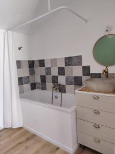 a bathroom with a tub and a sink and a mirror at Studio indépendant avec parking à Avignon in Avignon