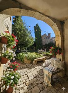 an archway with a bench in a garden with flowers at L'aparté Roussat in Langres