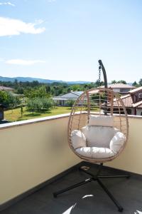 a rattan chair on a balcony with a view at I&R Apartma in Hrpelje